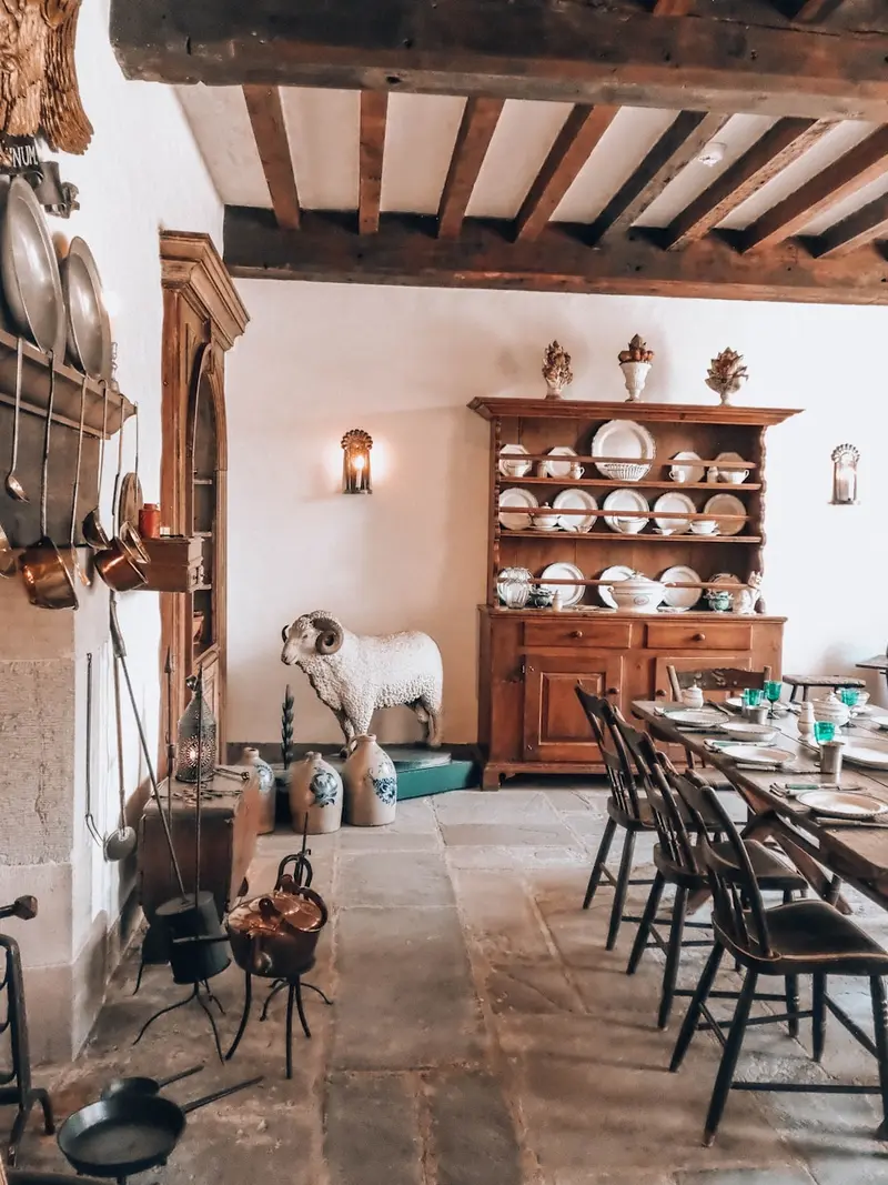 Sala de jantar rústica com vigas expostas e mobiliário de época